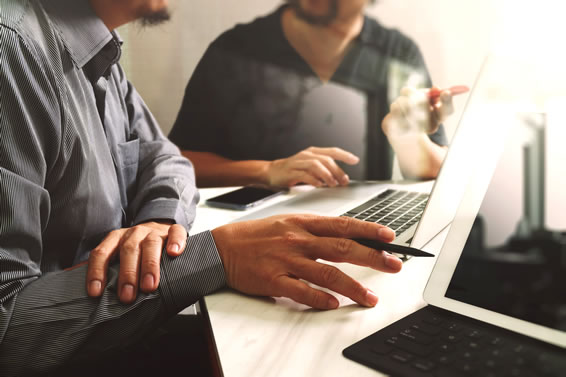 two men working on laptopl